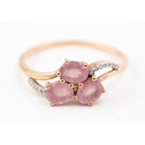 464 - A 9ct gold, pink sapphire, and diamond dress ring, set with three oval cut pale pink sapphires, with... 