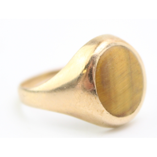 472 - A 9ct gold signet ring set with an oval tiger's eye, fully hallmarked to the inside shank, size U, 4... 