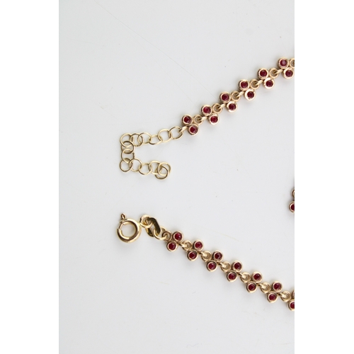 482 - A 14ct gold and ruby bracelet, set with thirty two panels each in the form of a pair of ruby set ber... 