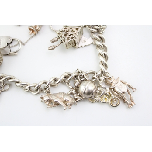 484 - A silver curb link charm bracelet with heart shaped padlock clasp, and fourteen charms, including ca... 