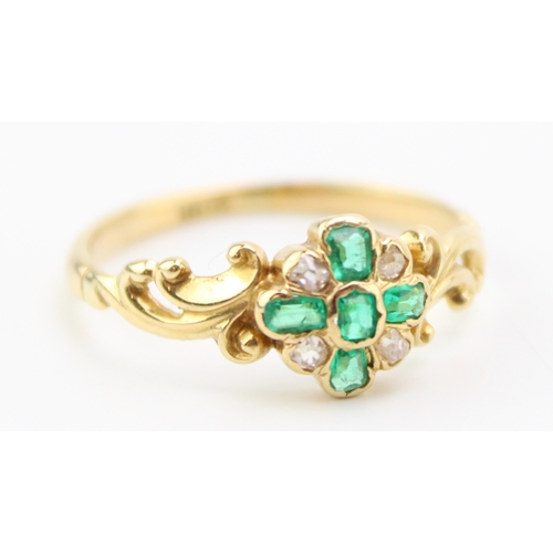 494 - An 18ct gold, diamond and emerald dress ring, with central quatrefoil of five diamonds interspersed ... 