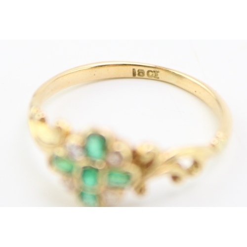 494 - An 18ct gold, diamond and emerald dress ring, with central quatrefoil of five diamonds interspersed ... 