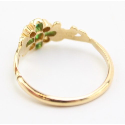 494 - An 18ct gold, diamond and emerald dress ring, with central quatrefoil of five diamonds interspersed ... 