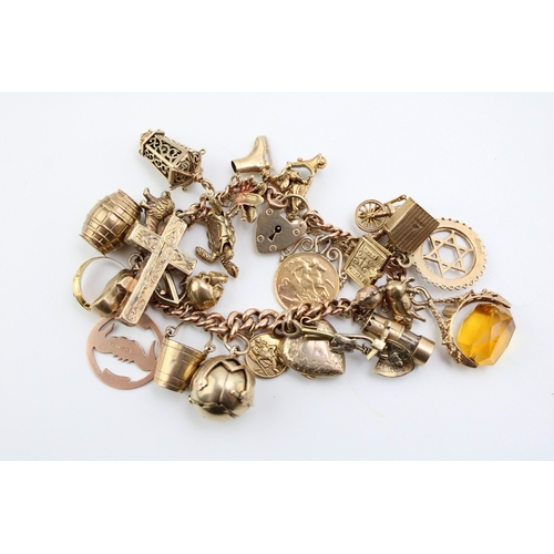 503 - A 9ct gold curb link charm bracelet with twenty seven charms, including a half sovereign, Queen Vict... 