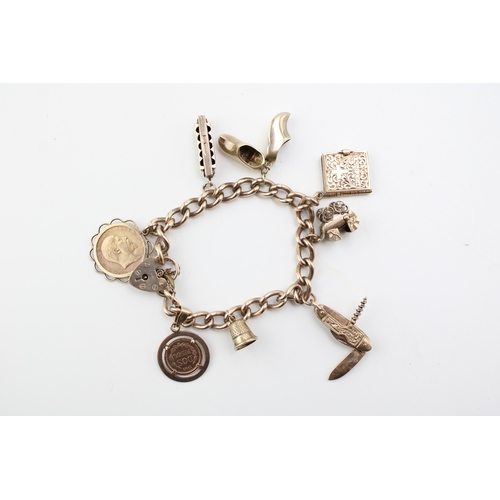 504 - A 9ct gold charm bracelet with heart shaped padlock clasp and eight charms comprising 1909 gold half... 