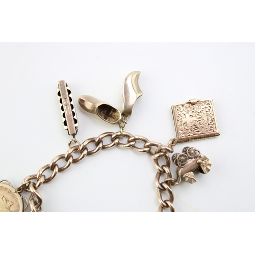 504 - A 9ct gold charm bracelet with heart shaped padlock clasp and eight charms comprising 1909 gold half... 