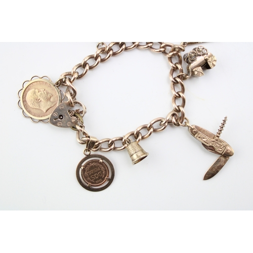 504 - A 9ct gold charm bracelet with heart shaped padlock clasp and eight charms comprising 1909 gold half... 