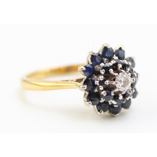 512 - An 18ct gold, sapphire and diamond cluster ring, of mid century design, set with two concentric circ... 