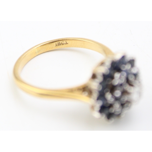 512 - An 18ct gold, sapphire and diamond cluster ring, of mid century design, set with two concentric circ... 