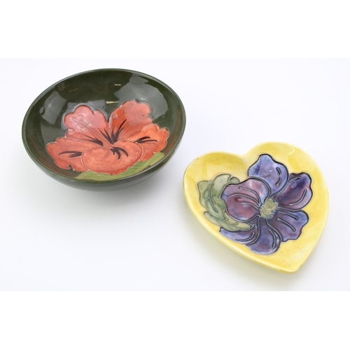 601 - A Moorcroft bowl in the 'Pink Hibiscus' pattern together with a heart shaped pin tray in the 'Clemat... 