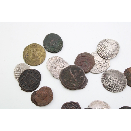 76 - A collection of hammered silver coins. Possibly of Moroccan / Islamic origin together with copper co... 