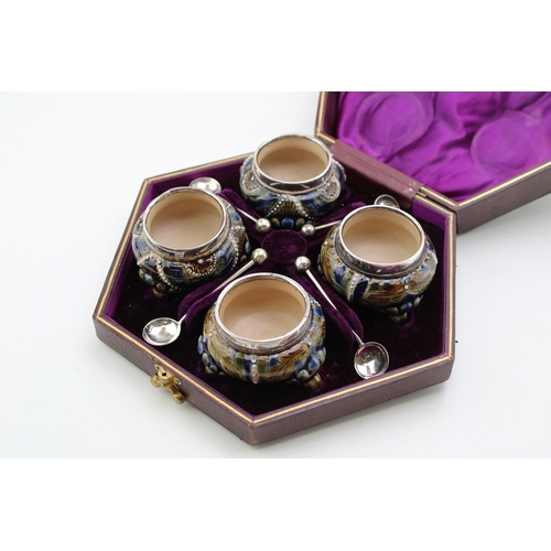 195 - Four Doulton Lambeth stoneware salt cellars, in fitted velvet-lined presentation case, silver rims, ... 