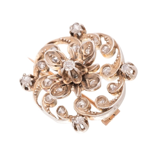 Victorian yellow metal (tests as 15ct gold) floral brooch, with raised central flower head, swirling decoration, set diamonds, 9.6g, 25mm wide.