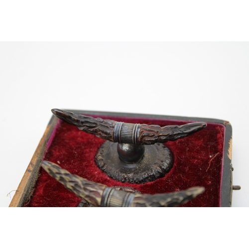 134 - A pair of cased 19th century American horn knife rests, white metal with carved horn in the form of ... 