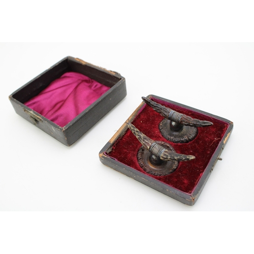 134 - A pair of cased 19th century American horn knife rests, white metal with carved horn in the form of ... 