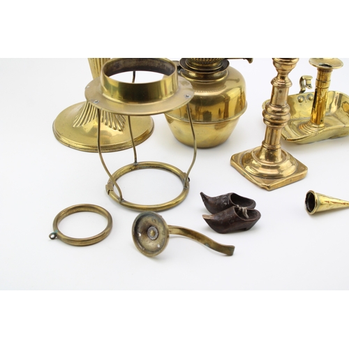 57 - A mixed collection of brass item to include an early 20th century oil lamp and other similar items, ... 
