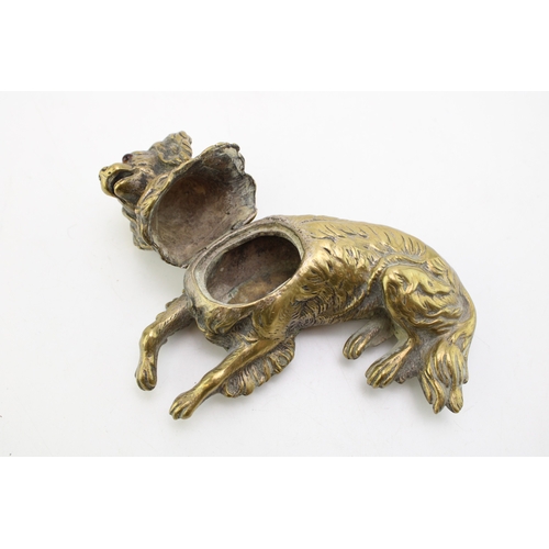 11 - A late c19th Victorian brass inkwell in the form of a spaniel dog with glass eyes with hinged head