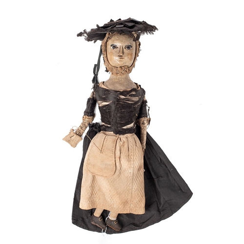 A Rare c18th painted English wood doll the carved wooden head with glass eyes and rouged cheeks wearing an original bonnet, original period Clothes, carved wooden hands & fingers holdingher sewing with ball of thread in her sewing bag, leather covered articulated arms & legs