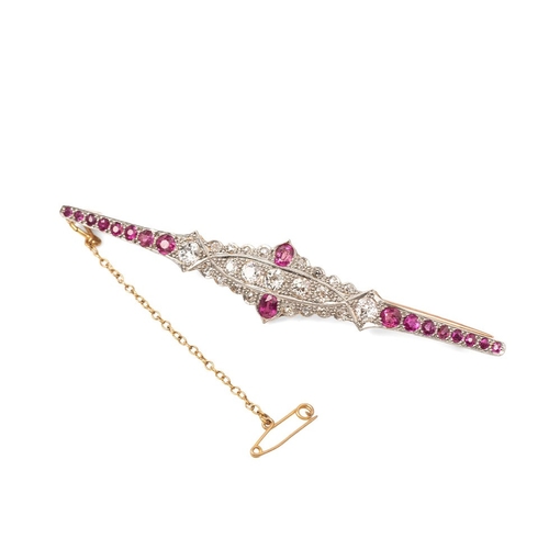 An Art Deco diamond and ruby brooch, set with three diamonds of approximately 4.0mm, 0.25ct, twenty three diamonds in total, with eighteen pink rubies, unmarked but testing as 18ct gold with 9ct gold pin, 8.8g.