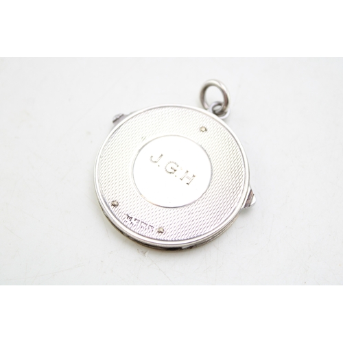 163 - A silver circular fob with integral steel folding manicure set, comprising scissors, file and knife,... 