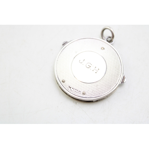 163 - A silver circular fob with integral steel folding manicure set, comprising scissors, file and knife,... 