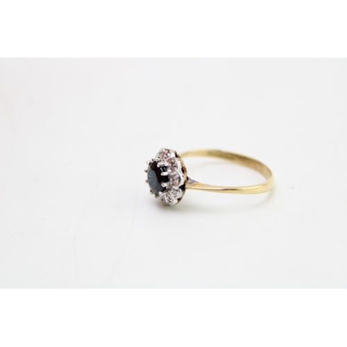 182 - An 18ct gold, sapphire and diamond flowerhead ring, the dark sapphire of approximately 5.6mm diamete... 