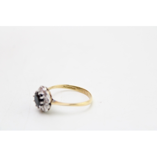 182 - An 18ct gold, sapphire and diamond flowerhead ring, the dark sapphire of approximately 5.6mm diamete... 