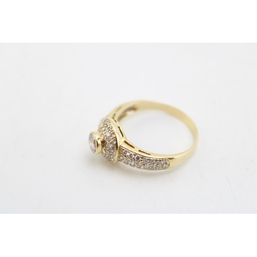 186 - An 18ct gold and diamond halo ring, the central diamond with three rows of diamond brilliants surrou... 