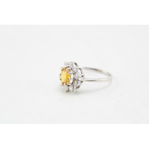 187 - An 18ct white gold, diamond and yellow sapphire dress ring of flowerhead form, set with central oval... 