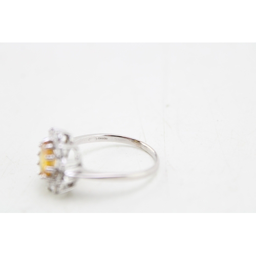 187 - An 18ct white gold, diamond and yellow sapphire dress ring of flowerhead form, set with central oval... 