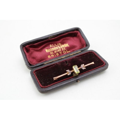 220 - An Art Nouveau 9ct gold, tourmaline and seed pearl bar brooch, the emerald cut central stone of appr... 