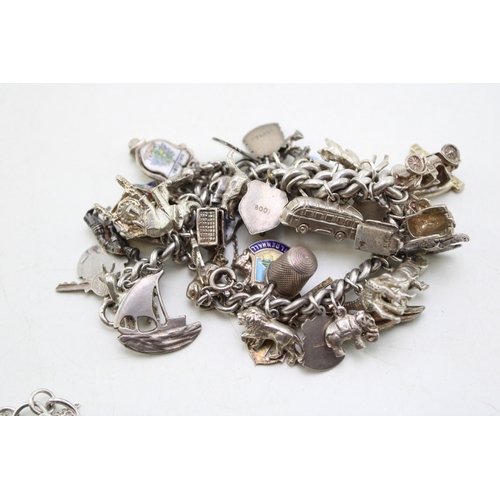 226 - A silver curb link charm bracelet, hallmarked to the links, with fourty three charms, in a variety o... 