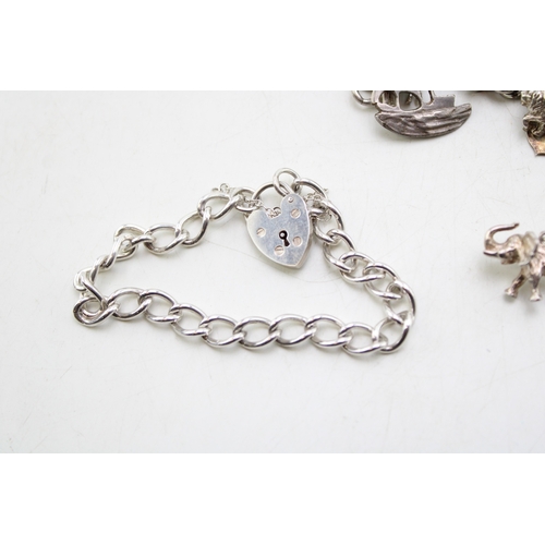 226 - A silver curb link charm bracelet, hallmarked to the links, with fourty three charms, in a variety o... 