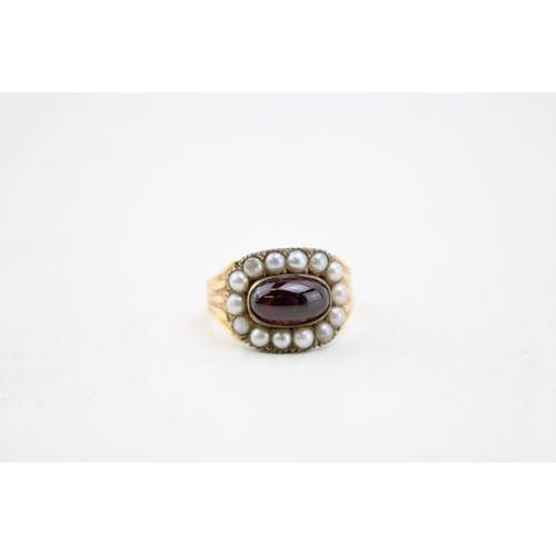 235 - A Victorian 15ct gold, garnet and seed pearl mourning ring, the panel set with a cabochon garnet sur... 