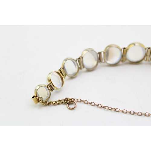 236 - A 9ct gold and moonstone bracelet set with eleven panels of oval moonstone cabochons, of graduated s... 