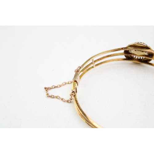 253 - An Art Deco, gold, citrine and pearl set bangle, the citrine of approximately 18.3mm, encircled by a... 