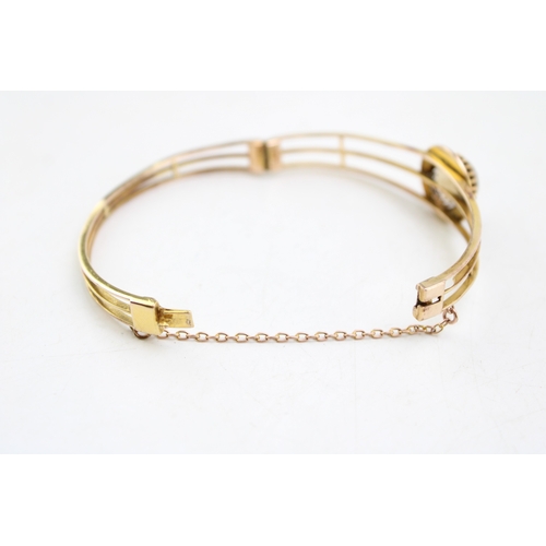 253 - An Art Deco, gold, citrine and pearl set bangle, the citrine of approximately 18.3mm, encircled by a... 