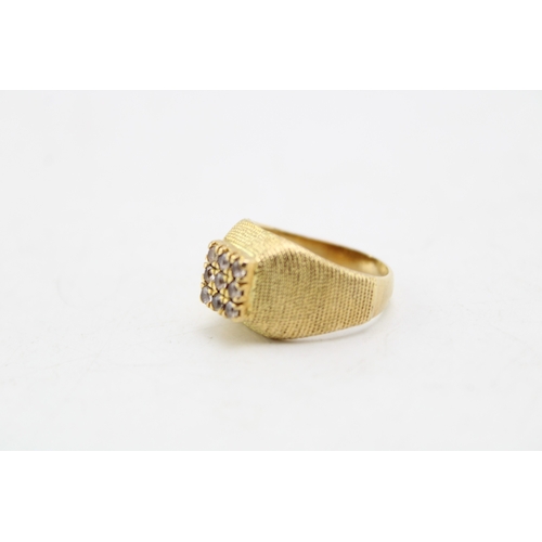 338 - A gold ring, of curved textured pyramidal form, set with square panel of nine small cubic zirconia, ... 