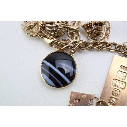 340 - A 9ct curb link gold charm bracelet, having rectangular padlock clasp and with fourteen oversized 9c... 