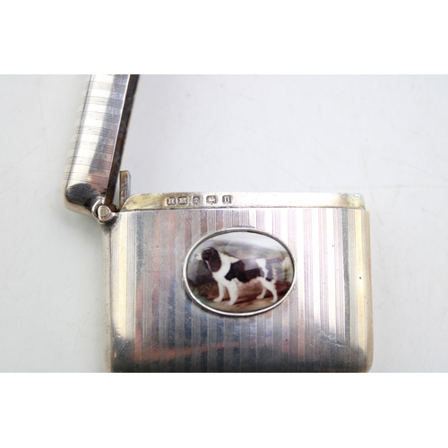 55 - A silver vesta case of curved form with engine turned engraving and applied plaque depicting a worki... 