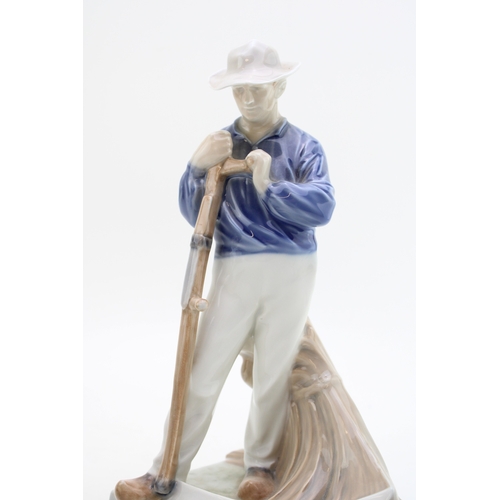 177 - A Royal Copenhagen figure of a farmer with scythe 685 with a B&G figure of a boy with a puppy (2).