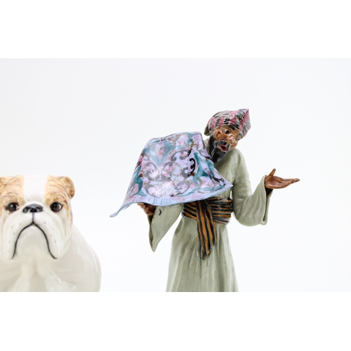 213 - A Janus pottery figure of a child with a cornucopia shell, a Royal Doulton bulldog and a Cooper Clay... 