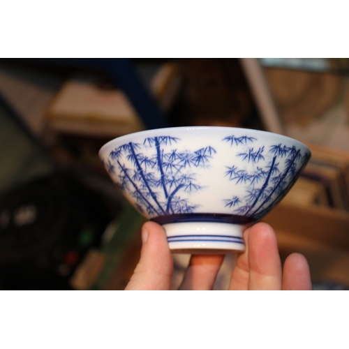 229 - Set of eleven Japanese blue and white rice bowls, together with a sake cup, (12).