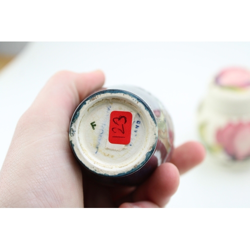 27 - A Moorcroft floral vase with a hibiscus on cream ginger jar, tallest 11.5cm tall (2), hairline to li... 