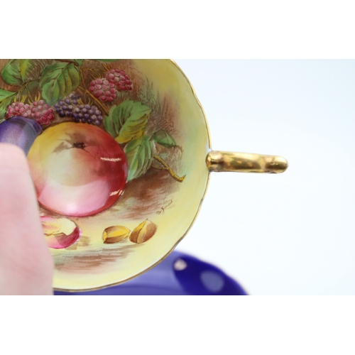 347 - Two Aynsley cups and saucers with fruit scene decoration, on cobalt blue backgrounds, both signed D ... 