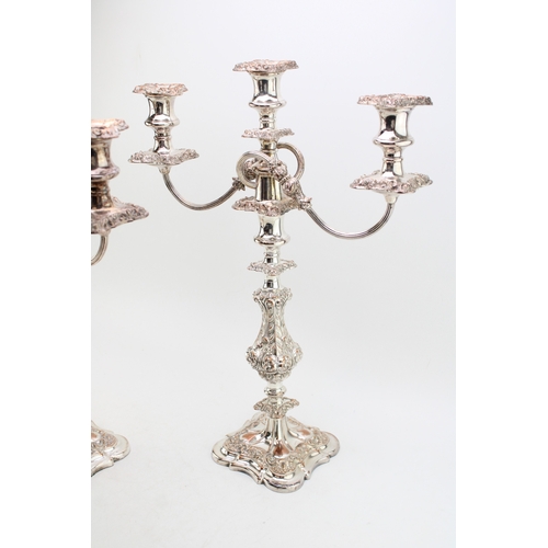 573 - A pair of Sheffield plate or similar three-sconce candelabras with scrolling acanthus leaf decoratio... 
