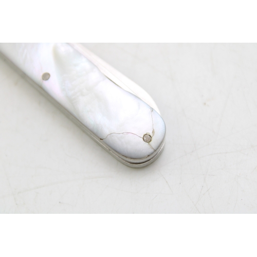 10 - A silver and mother of pearl travelling multi-tool pocket knife eating set, campaign style, split in... 