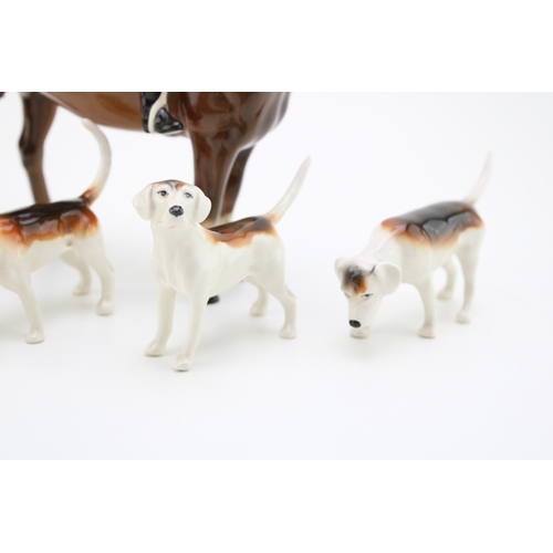 22 - Beswick Huntsman on brown horse together with four hounds, 21.5cm tall, (5).