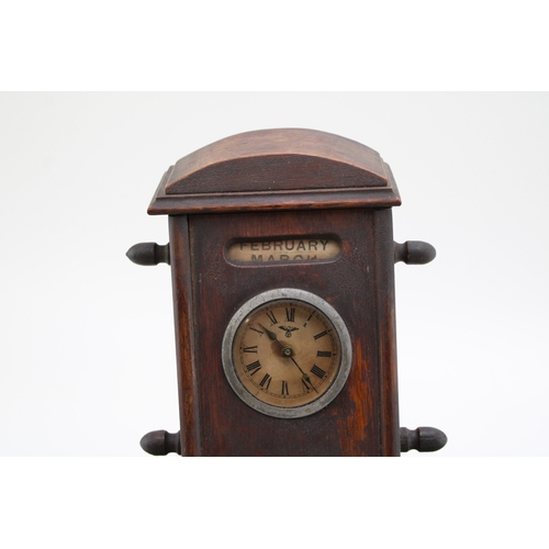 25A - An Edwardian oak perpetual calendar cum desk tidy, with central clock to calendar and scrolling days... 