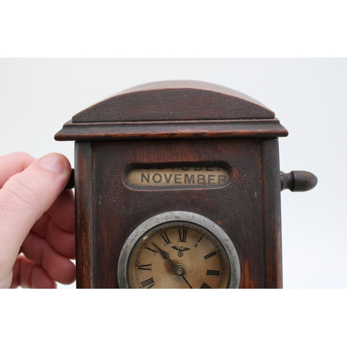 25A - An Edwardian oak perpetual calendar cum desk tidy, with central clock to calendar and scrolling days... 
